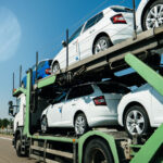 Auto transport truck carrying multiple cars on a highway.