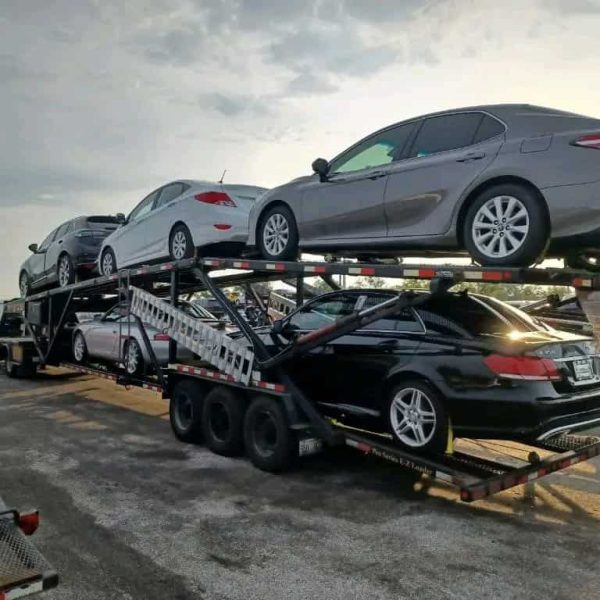 Auto transport trailer carrying multiple cars for shipping.