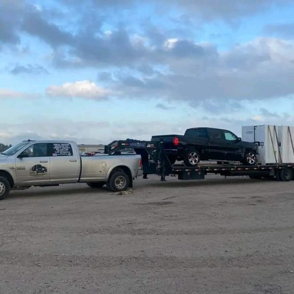 Auto transport truck carrying vehicles on open flatbed trailer.