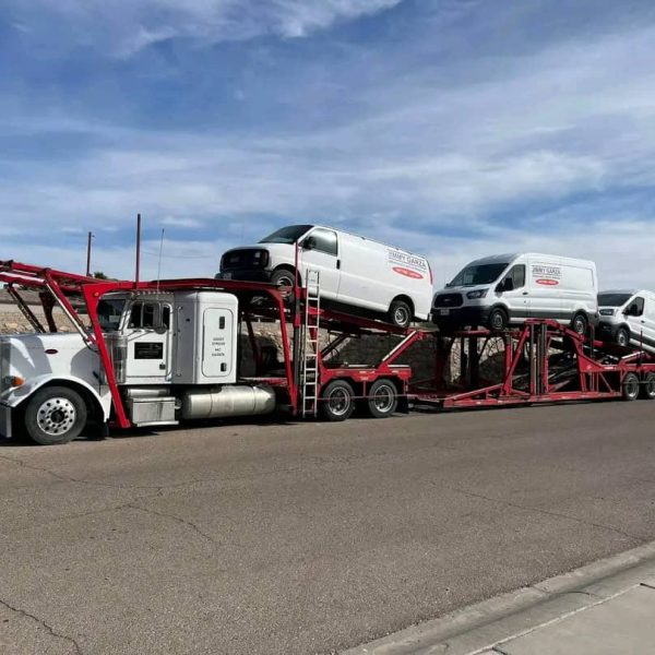 Auto transport truck carrying multiple vehicles on highway.