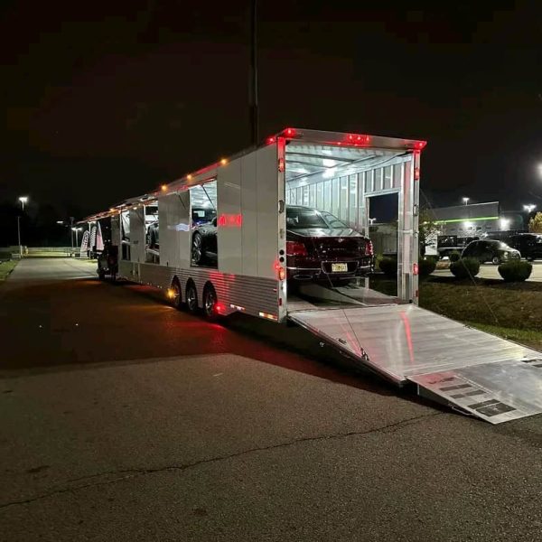 Car shipping truck at night with cars loaded for delivery.