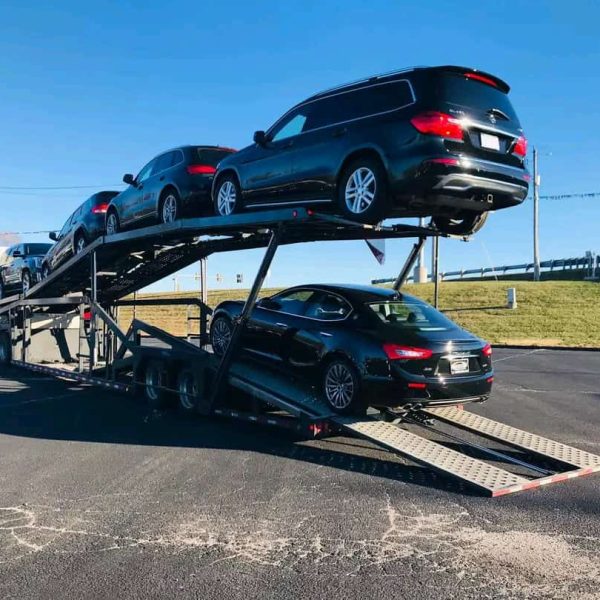 Car carrier truck transporting multiple vehicles on a highway.