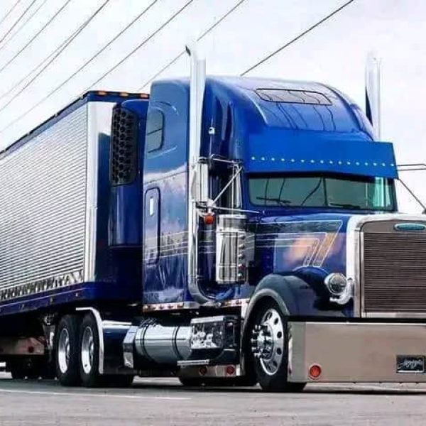 Blue semi-truck with trailer for auto transport services.