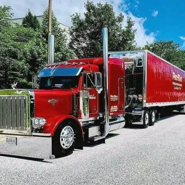 Red semi-truck with trailer for car shipping and auto transport services.